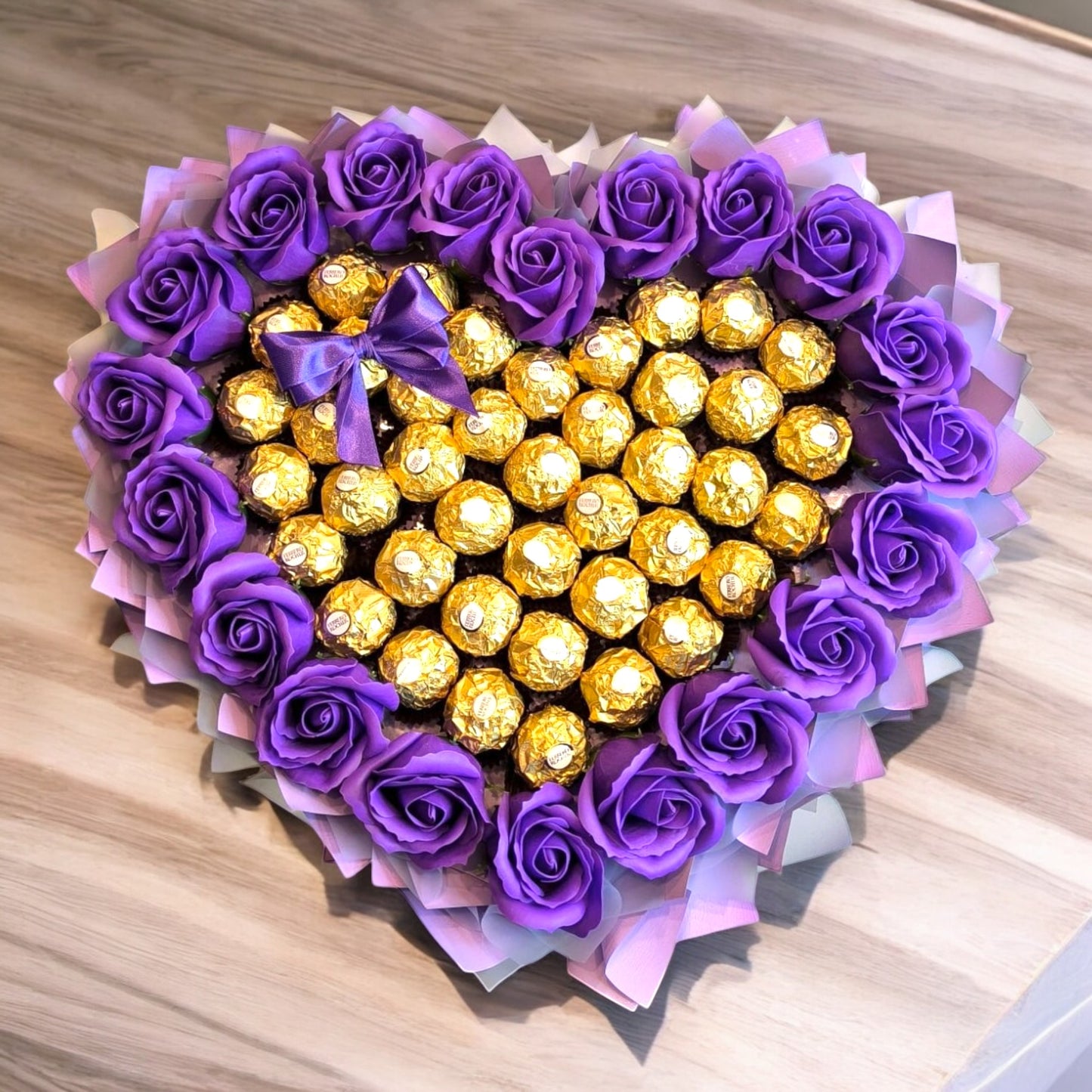 Herzförmiger Schokoladenstrauß „Lila Love“ mit Ferrero Rocher und künstlichen Rosen