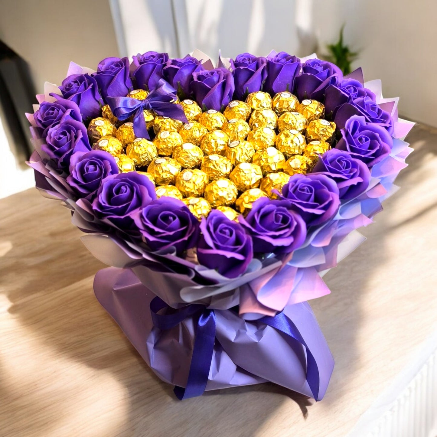 Herzförmiger Schokoladenstrauß „Lila Love“ mit Ferrero Rocher und künstlichen Rosen